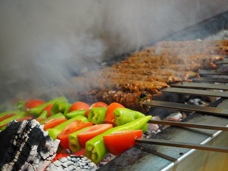 Adana kebabs and peppers on the charcoal grill