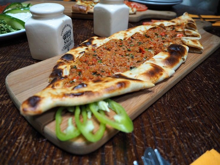 Minced lamb pide on a wooden board